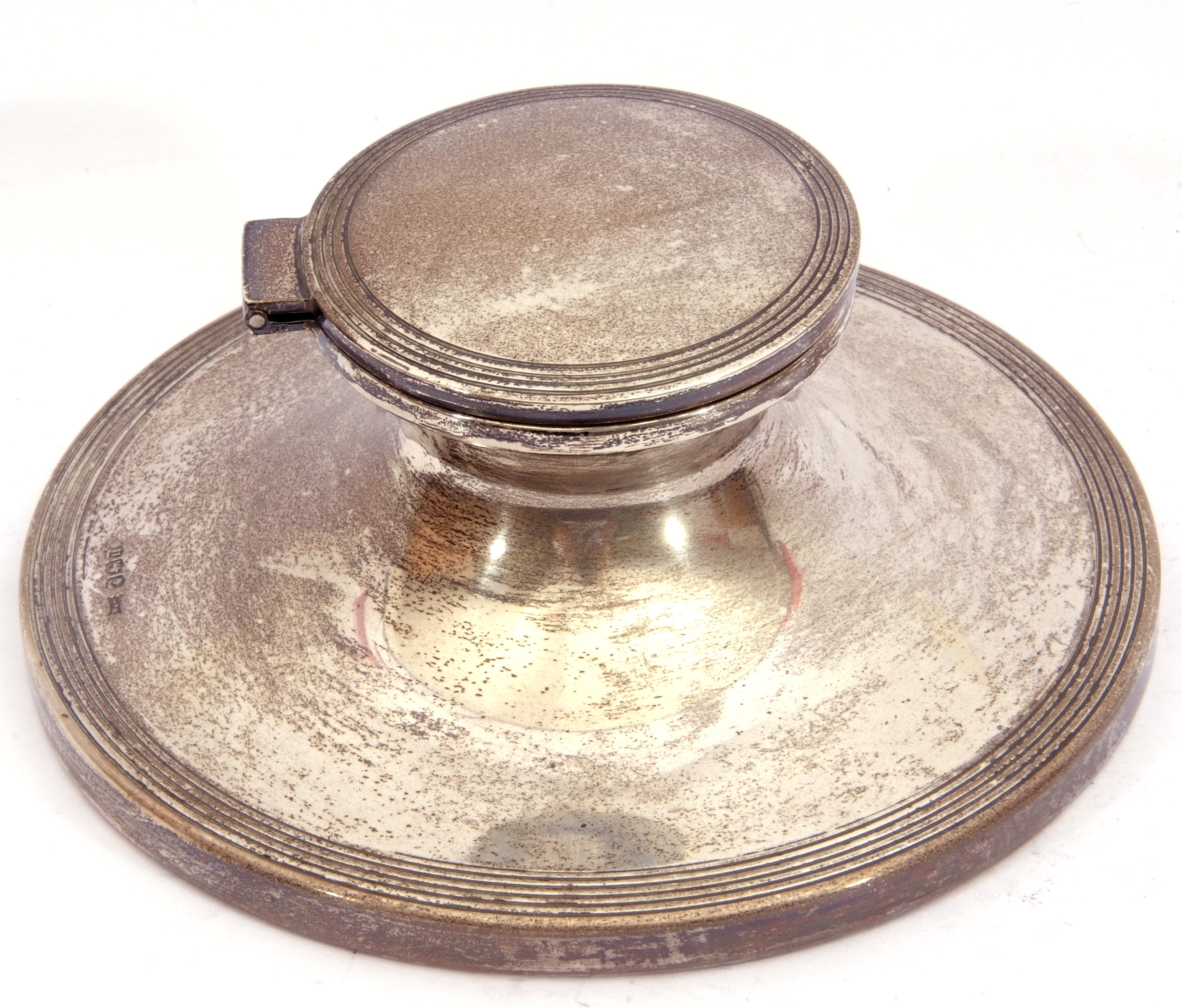 Silver capstan inkwell of typical form, the hinged lid and base with reeded borders to edges, no
