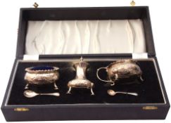 Cased silver condiment set comprising a hinged lidded mustard and liner, open salt and liner,