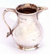 George V silver cream jug in the sparrow-beak style, having a plain round bellied body, a capped