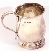 George VI silver mug of plain baluster shape, reeded handle to a raised spreading foot, 8 cm high,