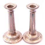 Pair of George V small candlesticks, panelled columns to stepped circular bases (loaded), Birmingham