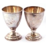 Two sterling wine goblets having plain round tapering bodies with reeded borders, each sitting on