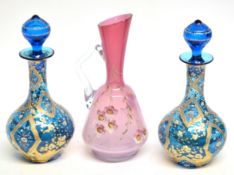 Pink glass ewer with floral design together with two Bohemian style carafes and stoppers, the