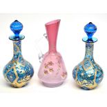 Pink glass ewer with floral design together with two Bohemian style carafes and stoppers, the