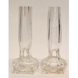 Pair of early 20th century glass bud vases raised on four stub feet with reeded glass, 20cm high (