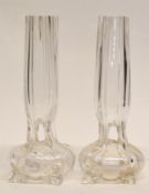 Pair of early 20th century glass bud vases raised on four stub feet with reeded glass, 20cm high (