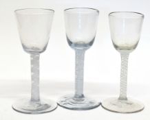 Group of three 18th century wine glasses all with air twist and central gauze on conical feet, (