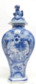 Dutch Delft vase and cover with dog finial, the vase painted with a landscape scene and flowers,