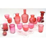 Collection of cranberry glass wares including six wine glasses of various sizes, two jugs, small