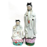 Two Chinese porcelain models of Guan Yin decorated in typical fashion, both on green bases,