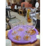 WATER JUG WITH AMBER HANDLE AND AMBER COLOURED GLASS BASE, TOGETHER WITH FOUR BEAKERS