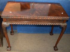 Mahogany card table with folding and swivel top gadrooned frieze and raised on cabriole supports
