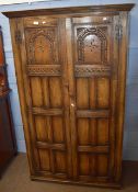 Reproduction oak wardrobe with panel doors enclosing hanging space 1.06m wide