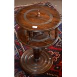 Unusual swivelling pedestal table raised on a ring turned support and circular base with ball feet