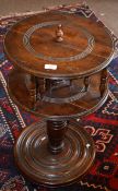 Unusual swivelling pedestal table raised on a ring turned support and circular base with ball feet