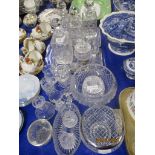 VARIOUS GLASS DECANTERS ON TRAYS AND OTHER GLASS WARES INCLUDING CANDLESTICKS AND SMALL VASES