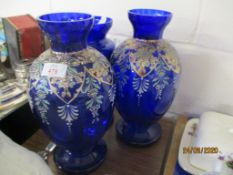 TWO BALUSTER BLUE GLASS VASES OVERLAID WITH PAINTED FLORAL DECORATION AND FURTHER BLUE GLASS LUSTRE