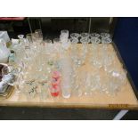 EXTENSIVE QUANTITY OF GLASS WARES INCLUDING WINE GLASSES, VASES, TUMBLERS ETC