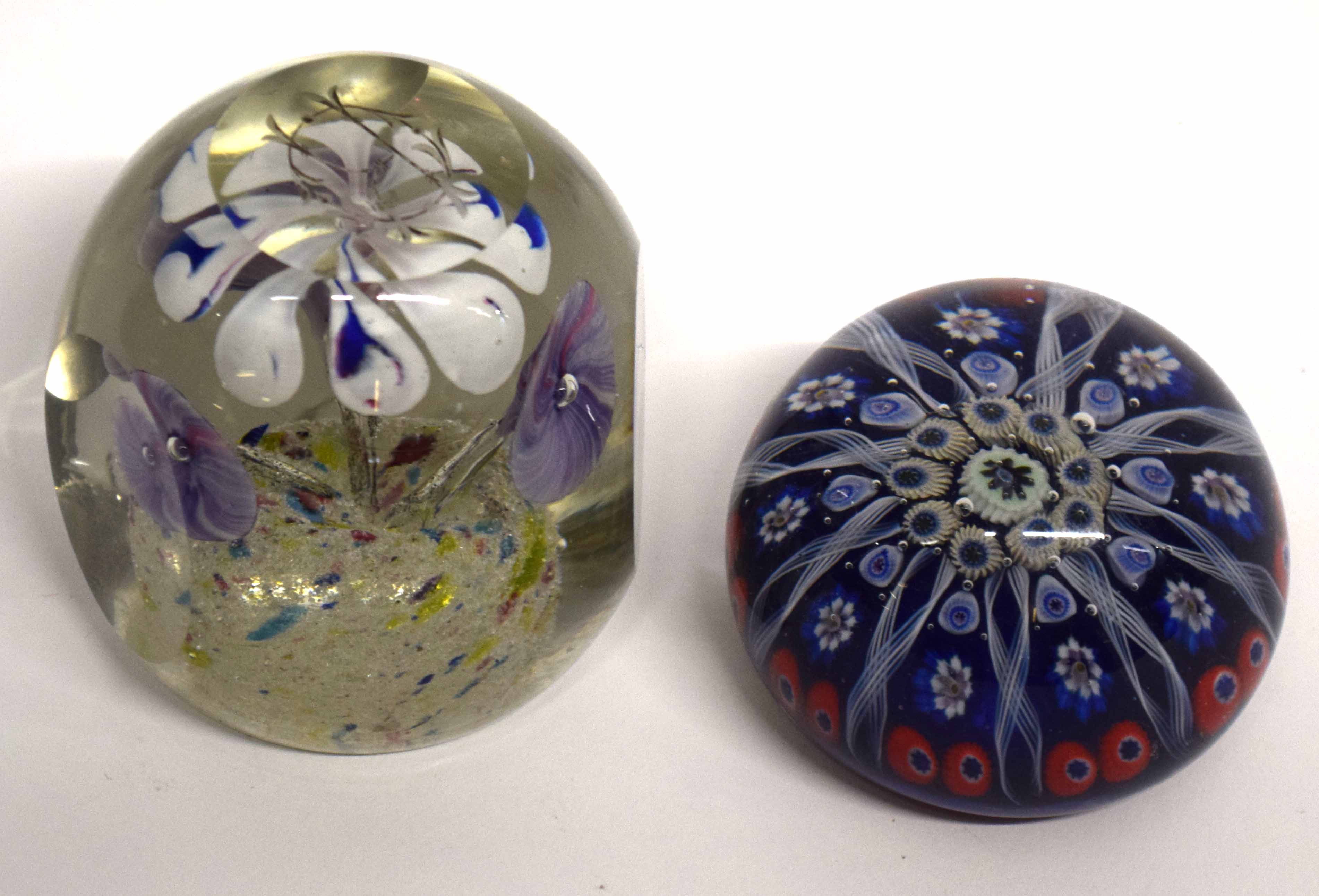 Two glass paperweights, one of a dump type with floral design, the other with various floral canes