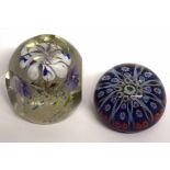 Two glass paperweights, one of a dump type with floral design, the other with various floral canes