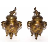 Oriental brass urns with eagle type handles and applied flowers in copper, the urns standing on