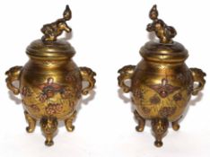 Oriental brass urns with eagle type handles and applied flowers in copper, the urns standing on