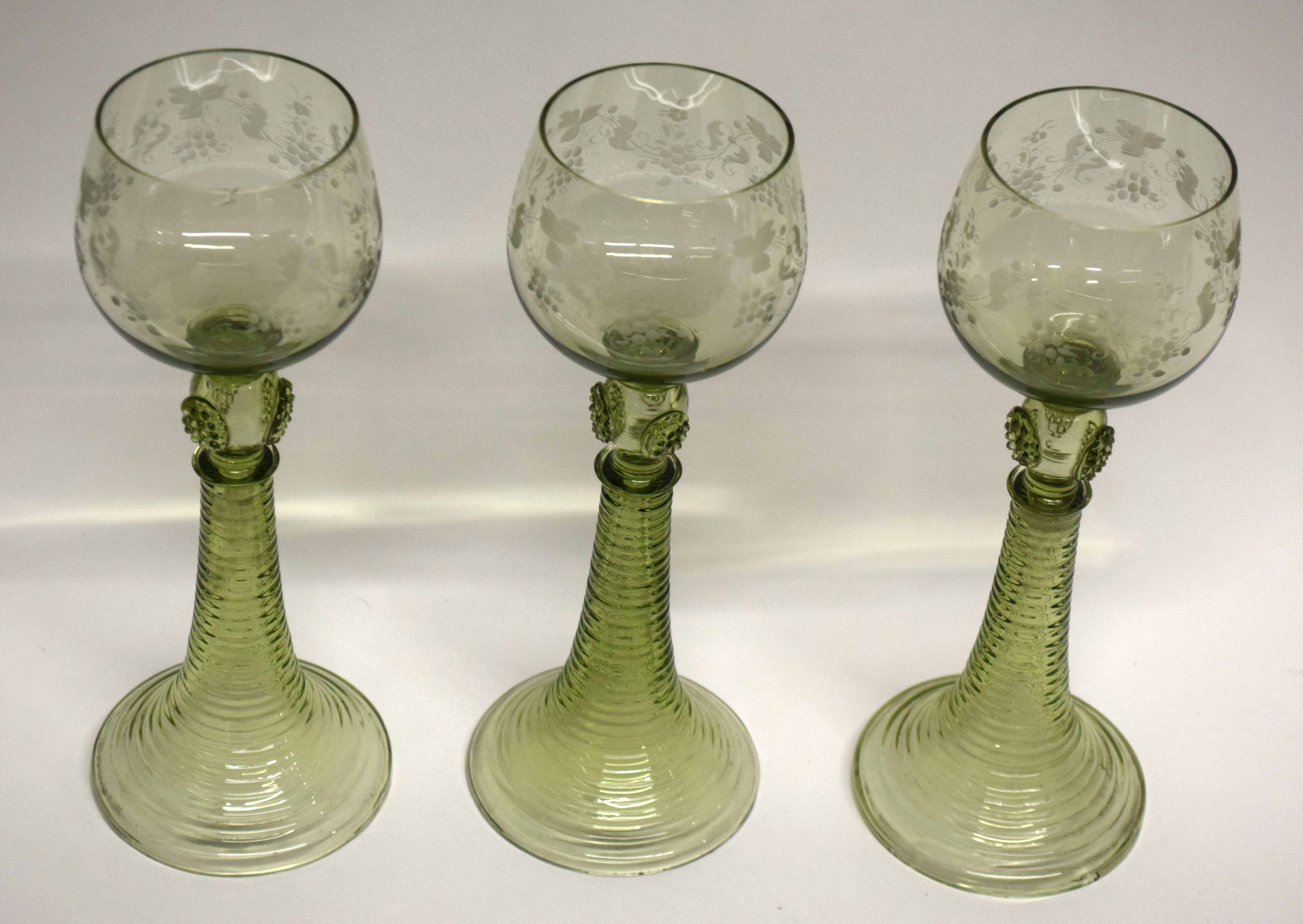 Group of three Bohemian style wine glasses with engraved floral decoration above a knopped stem (3)