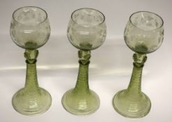 Group of three Bohemian style wine glasses with engraved floral decoration above a knopped stem (3)