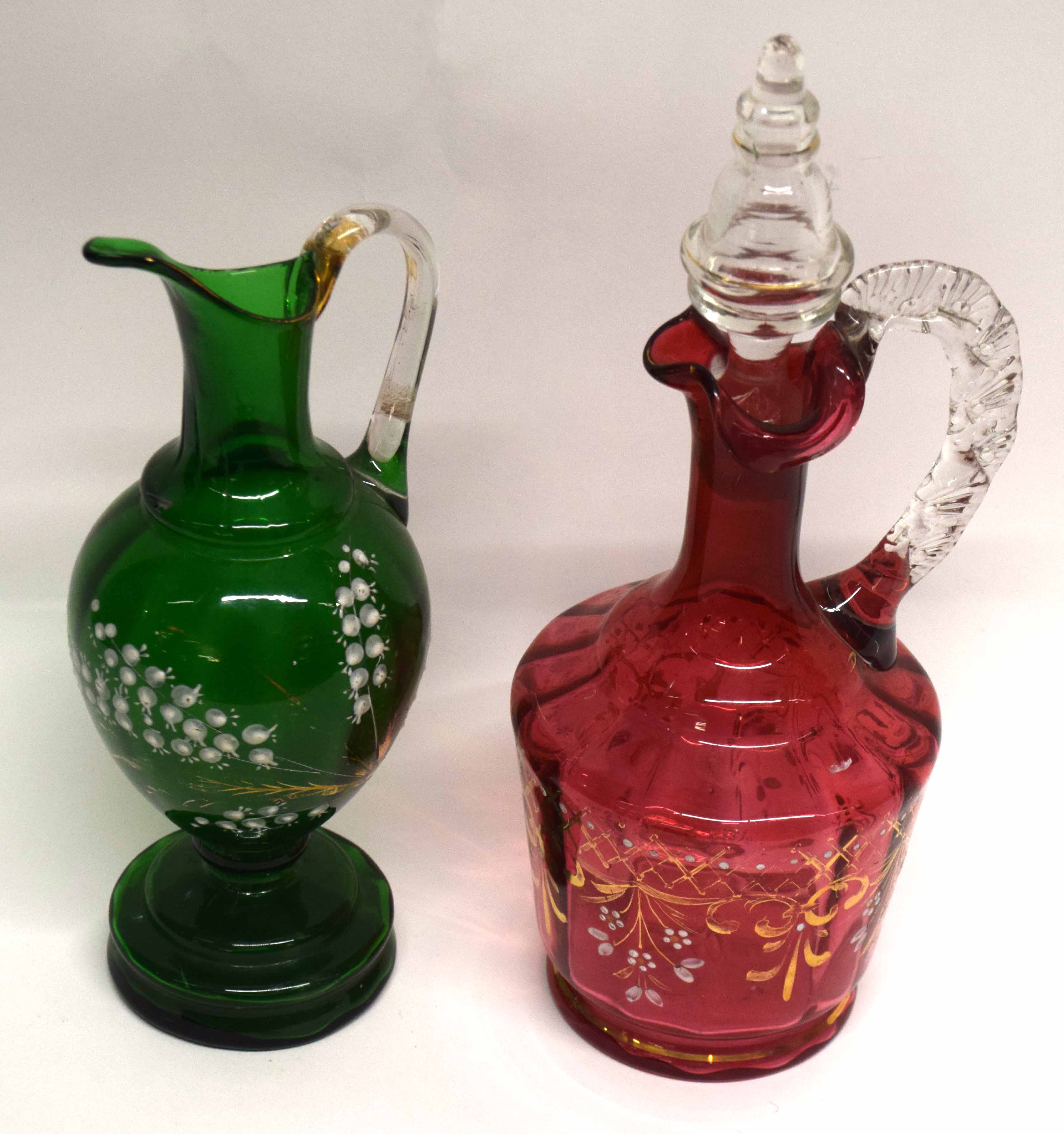 Late 19th century green glass ewer with a painted floral design, together with a cranberry