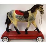 20th century wooden child~s painted horse with later base on wheels
