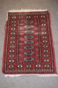 Bokhara style small prayer rug with central panel of lozenges mainly rust field (worn) 95 x 65cm