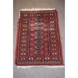 Bokhara style small prayer rug with central panel of lozenges mainly rust field (worn) 95 x 65cm