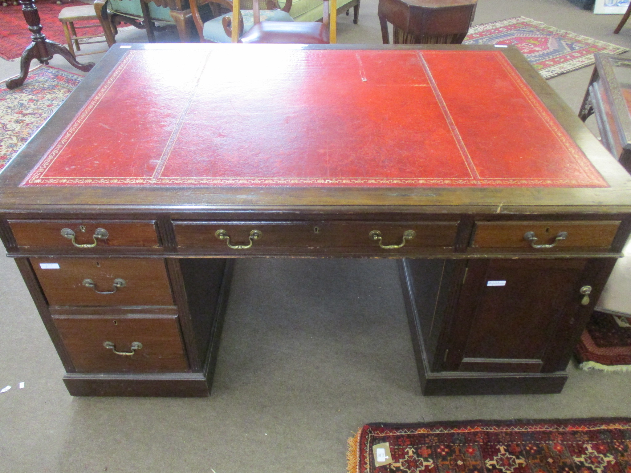 Late 19th/early 20th century mahogany partner~s desk with gilt tooled red inset, the two pedestals