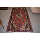 Caucasian carpet with central geometric lozenge, triple gull border, mainly red and blue field,