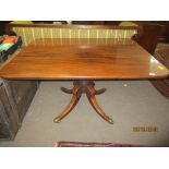 Regency period mahogany pedestal dining table raised on a quadruped base with brass caps and