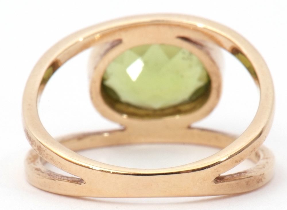9ct gold peridot ring, the oval faceted peridot bezel set between split plain polished shoulders, - Image 5 of 8