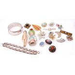 Two trays to include a large modern metal hinged bracelet, a cushion doll, various costume brooches,