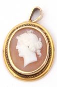 Antique carved shell cameo oval pendant depicting a classical lady, framed in a yellow metal mount