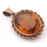 Amber coloured glass faceted oval pendant framed in a rope twist mount stamped 9ct, 28 x 22mm