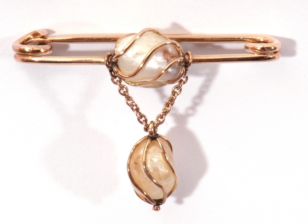 Baroque pearl pin brooch centring a wire work set baroque pearl with similar set dropper below,