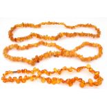 Mixed Lot: polished amber flat bead necklace of irregular form, together with two natural amber