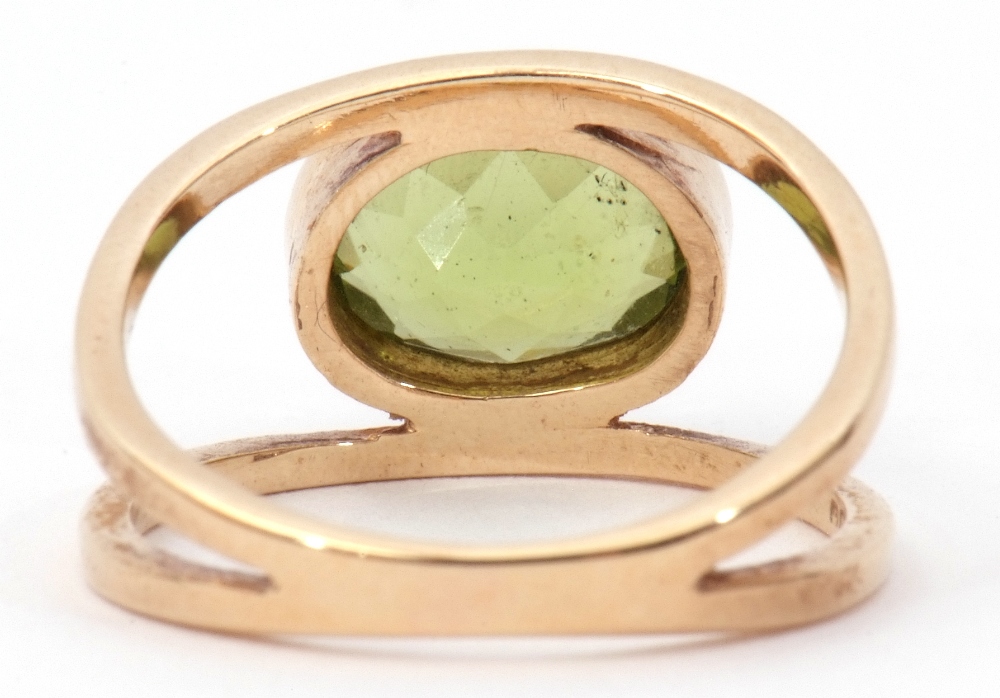 9ct gold peridot ring, the oval faceted peridot bezel set between split plain polished shoulders, - Image 4 of 8