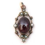 Victorian gilt metal, garnet and seed pearl set pendant, the cabochon oval shaped garnet in cut down