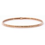 9ct gold bangle with a continuous stylised engraved design, 7cm diam, 3.7gms