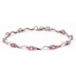 Modern 750 stamped pink sapphire and diamond set articulated bracelet, featuring 10 oval pink