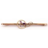 9ct stamped amethyst brooch of open work design, centring an amethyst set flower (one stone missing)