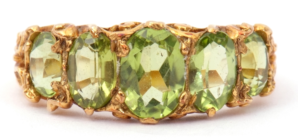 9ct gold five stone peridot ring, featuring five graduated oval cut peridots, claw set in carved