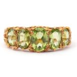 9ct gold five stone peridot ring, featuring five graduated oval cut peridots, claw set in carved