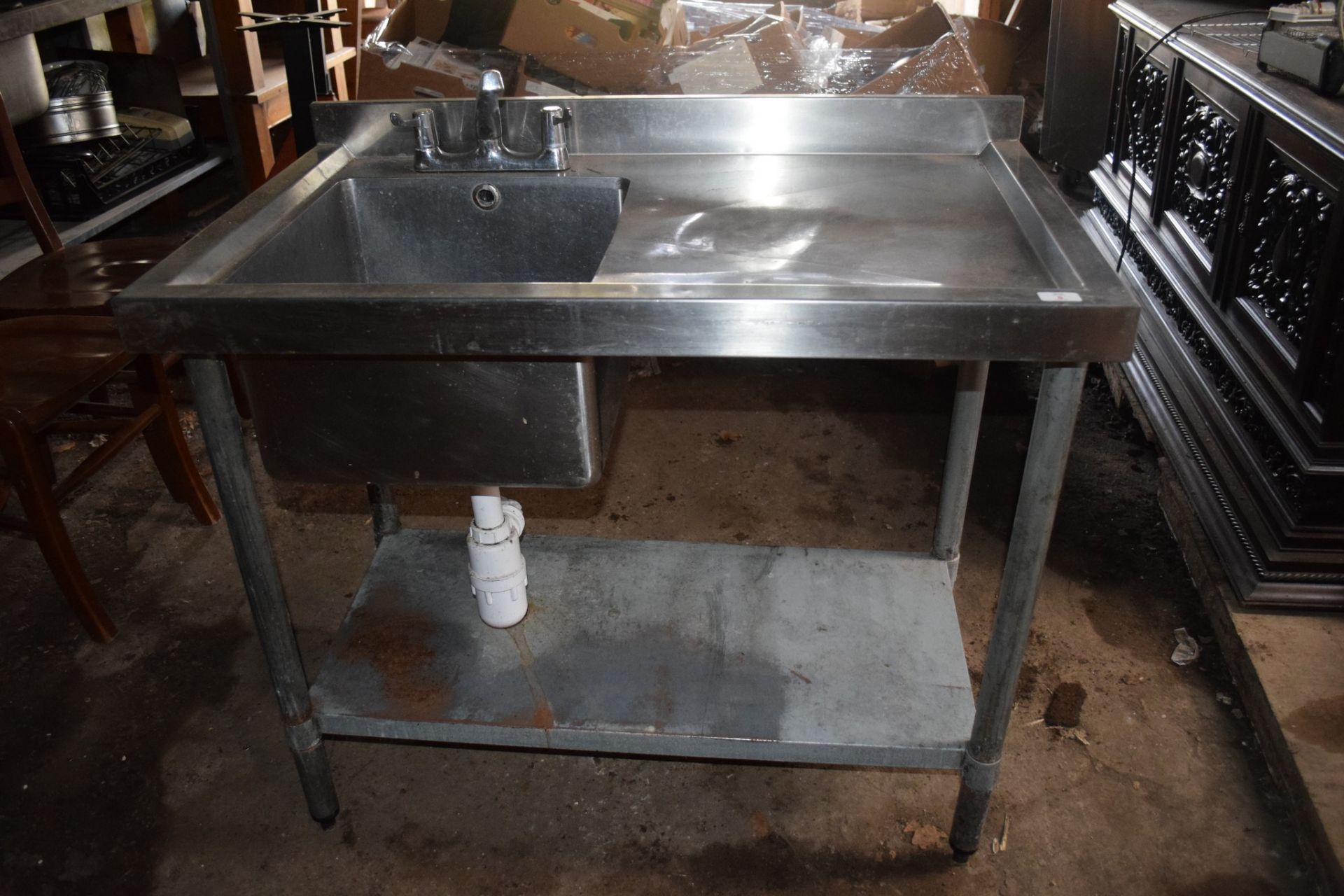 Stainless steel single drainer Sink, on metal stand with shelf beneath.