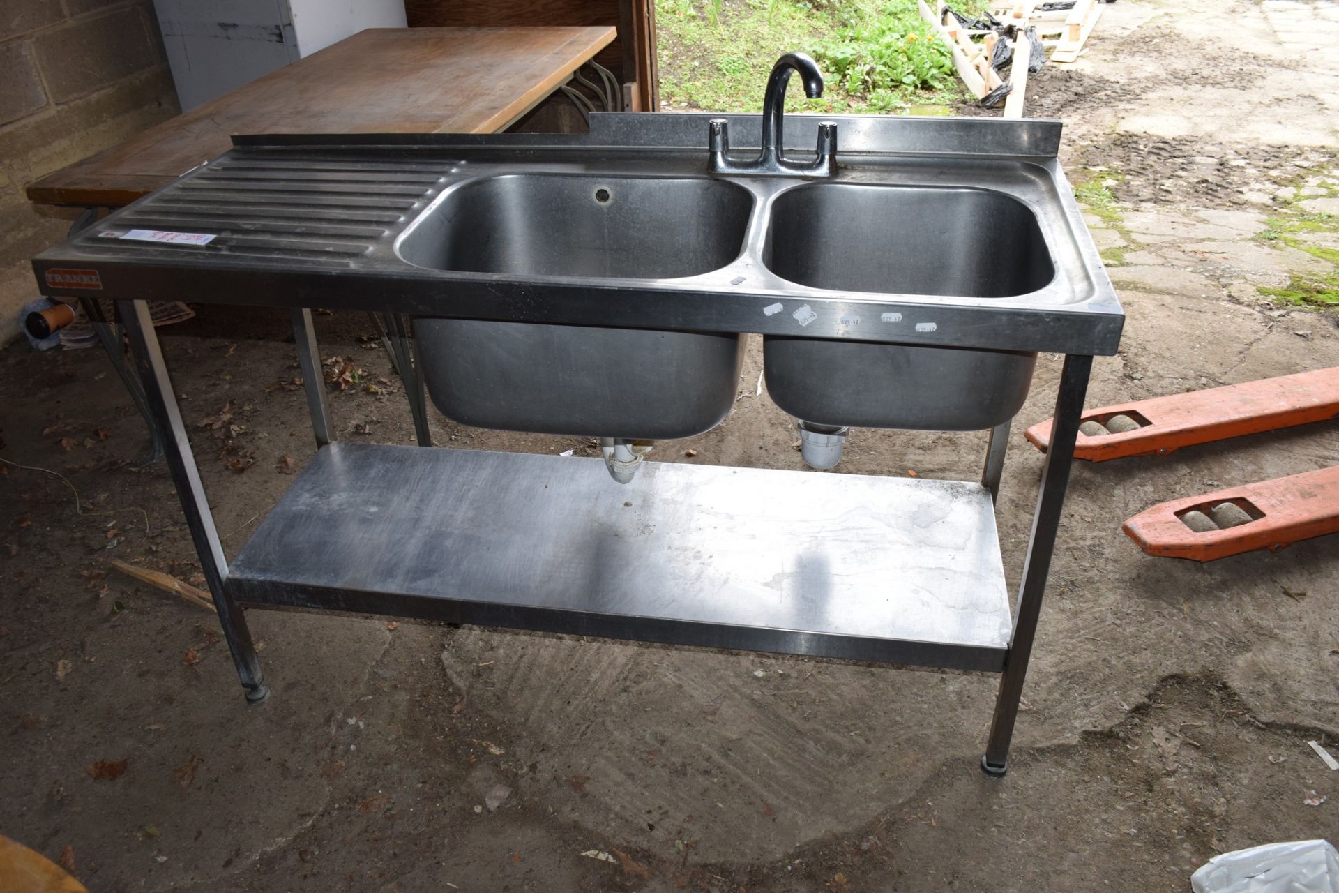 Large stainless steel double Sink, on stand with single drainer to left.